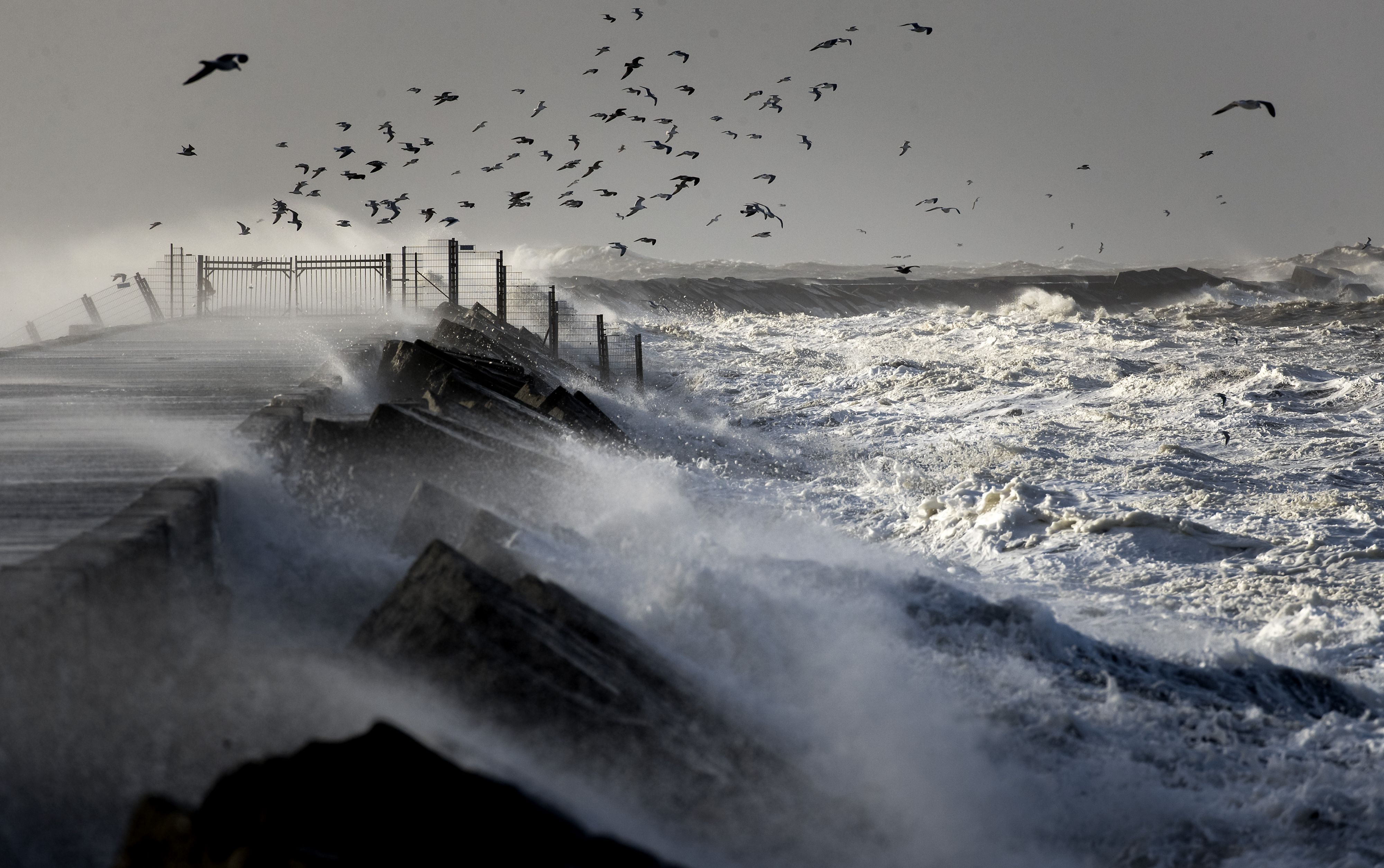 Grote golven slaan tegen de afgesloten pier tijdens de storm aan het begin van dit jaar. 