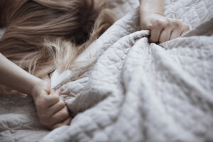 Een vrouw in bed onder de dekens