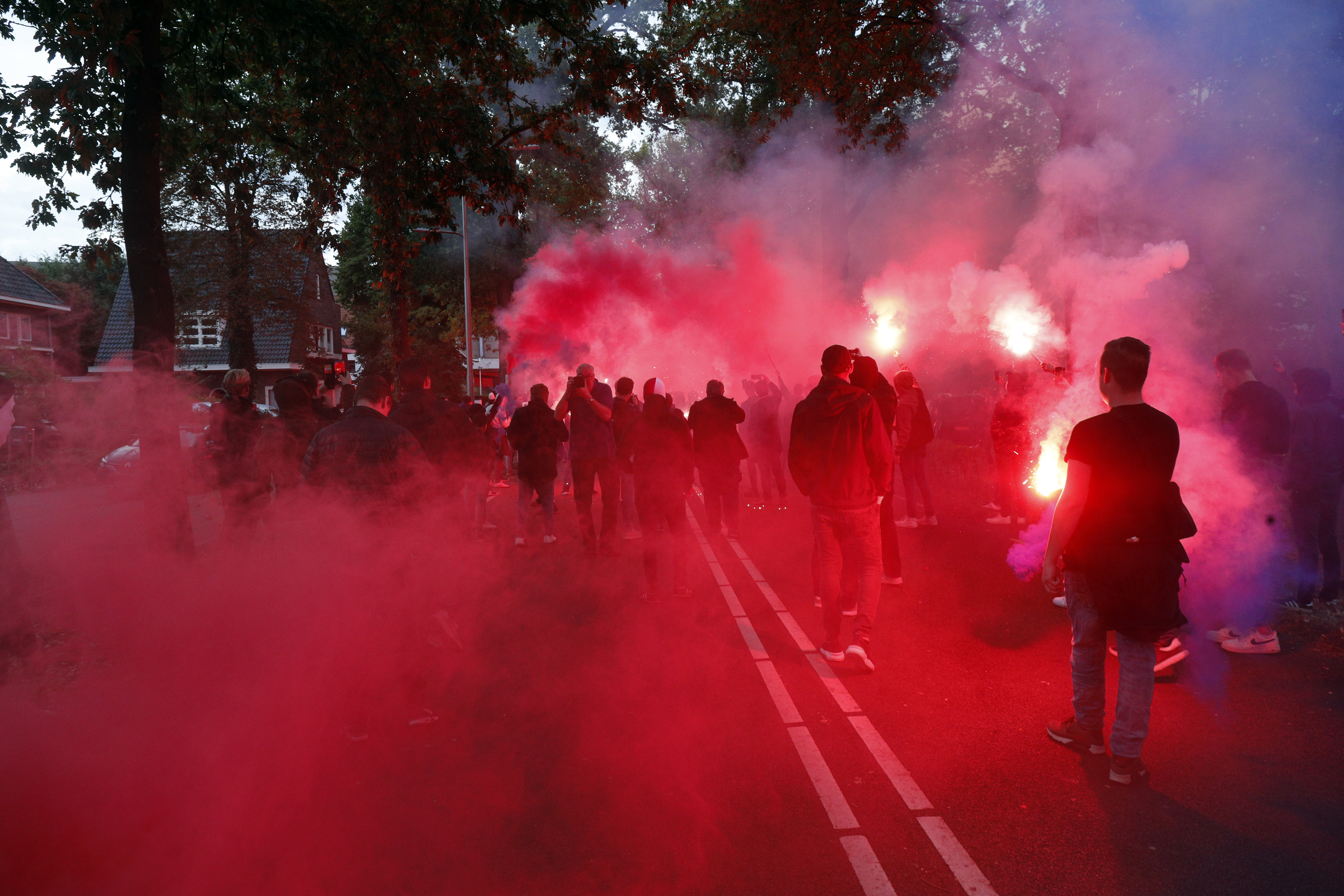 Op deze foto zijn supporters van Willem II te zien, er is veel rode rook.