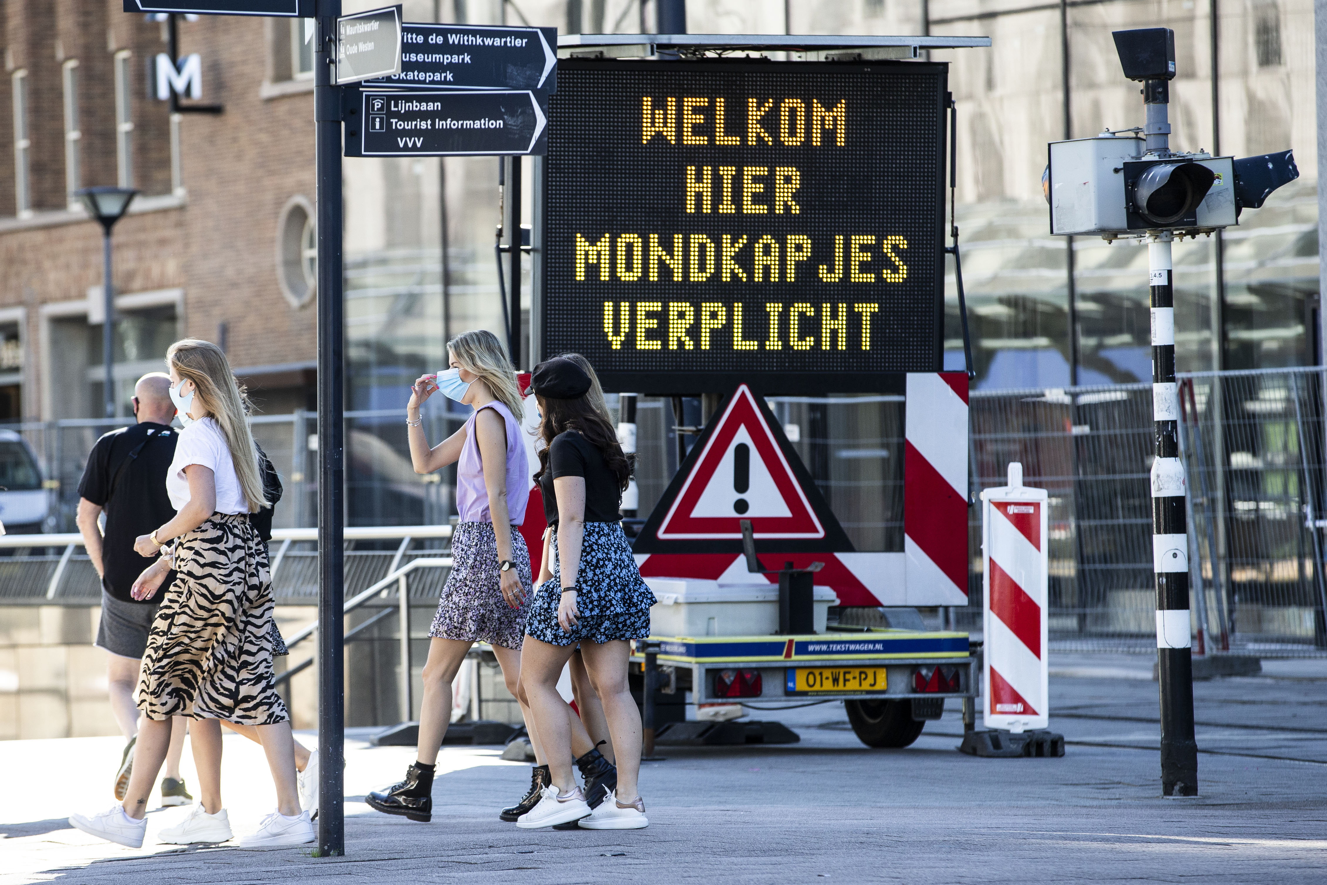 Op deze foto is een bord te zien met daarop 'welkom, hier mondkapjes verplicht' in Rotterdam.