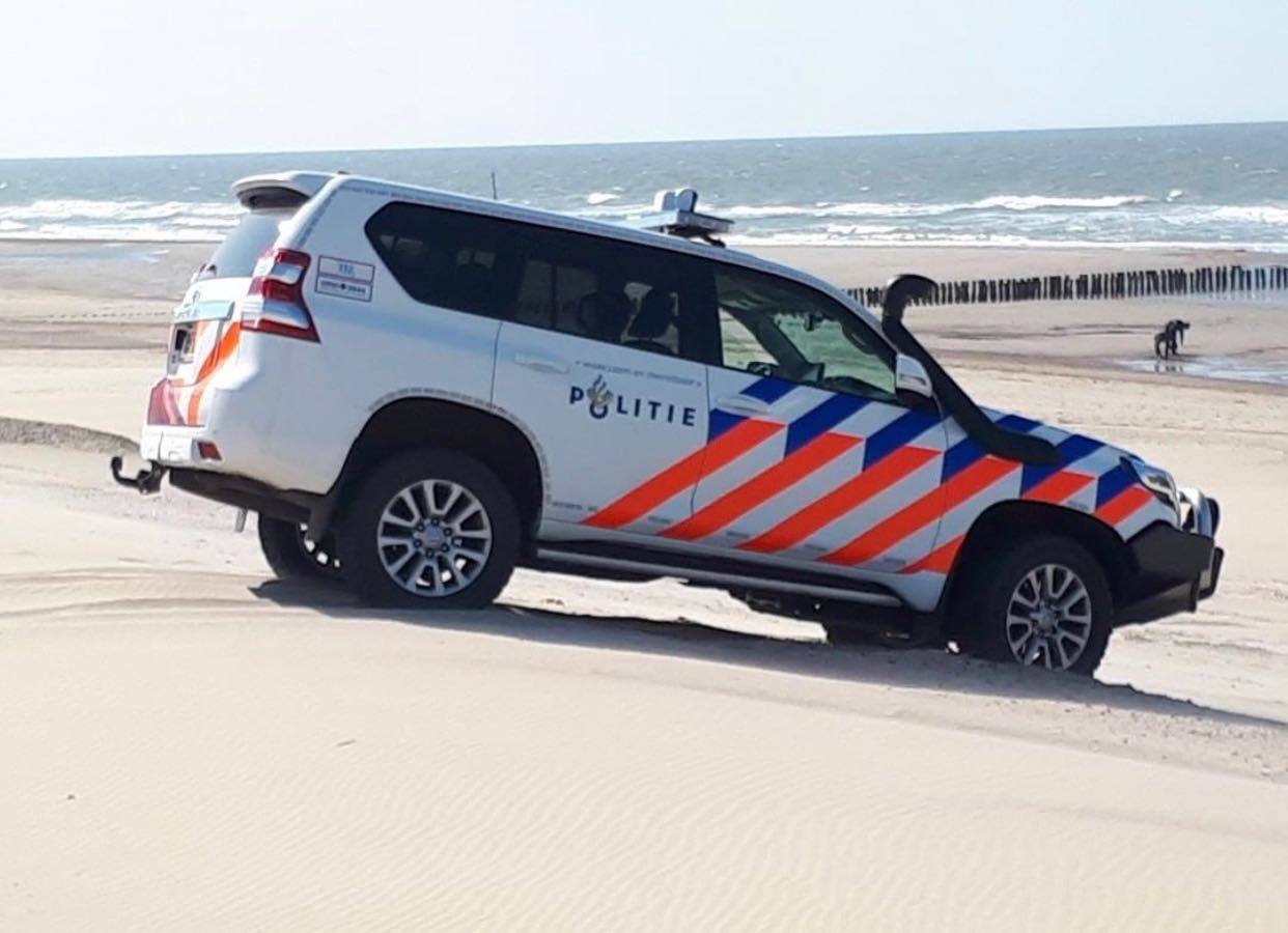 Op deze foto is een politieauto te zien op het strand waar de cocaïne was aangespoeld.