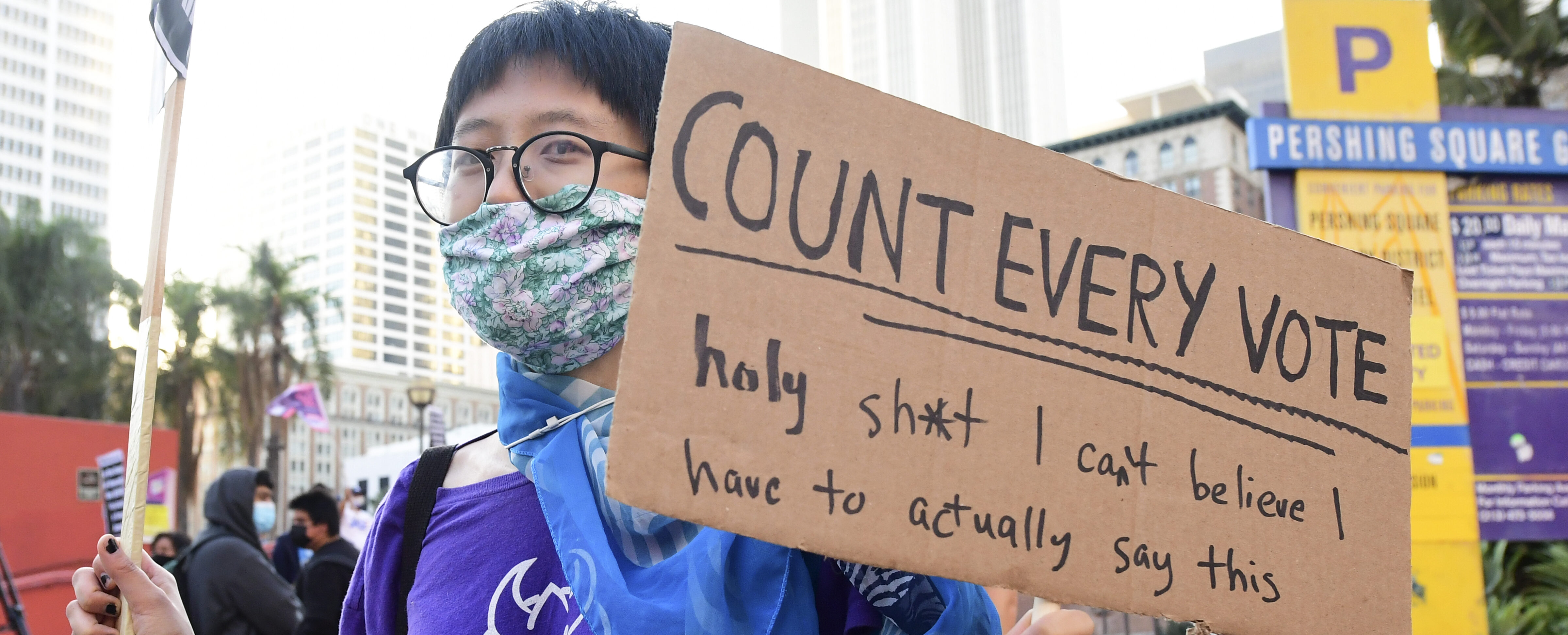 Een vrouw houdt een bord vast met 'count every vote'.