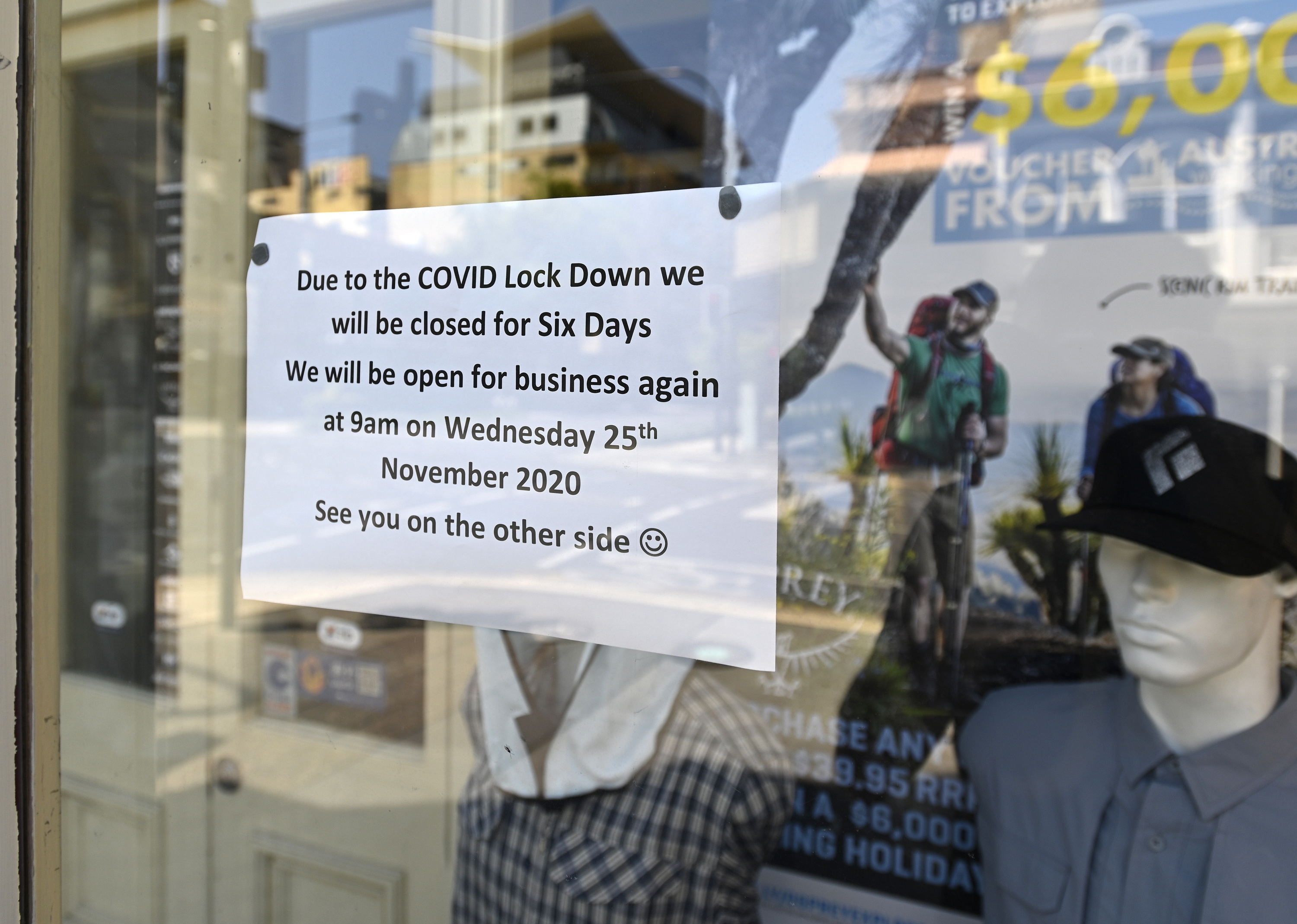 Een foto van een winkel, met een briefje op het raam geplakt. Er staat op 'door de lockdown zijn wij gesloten'.