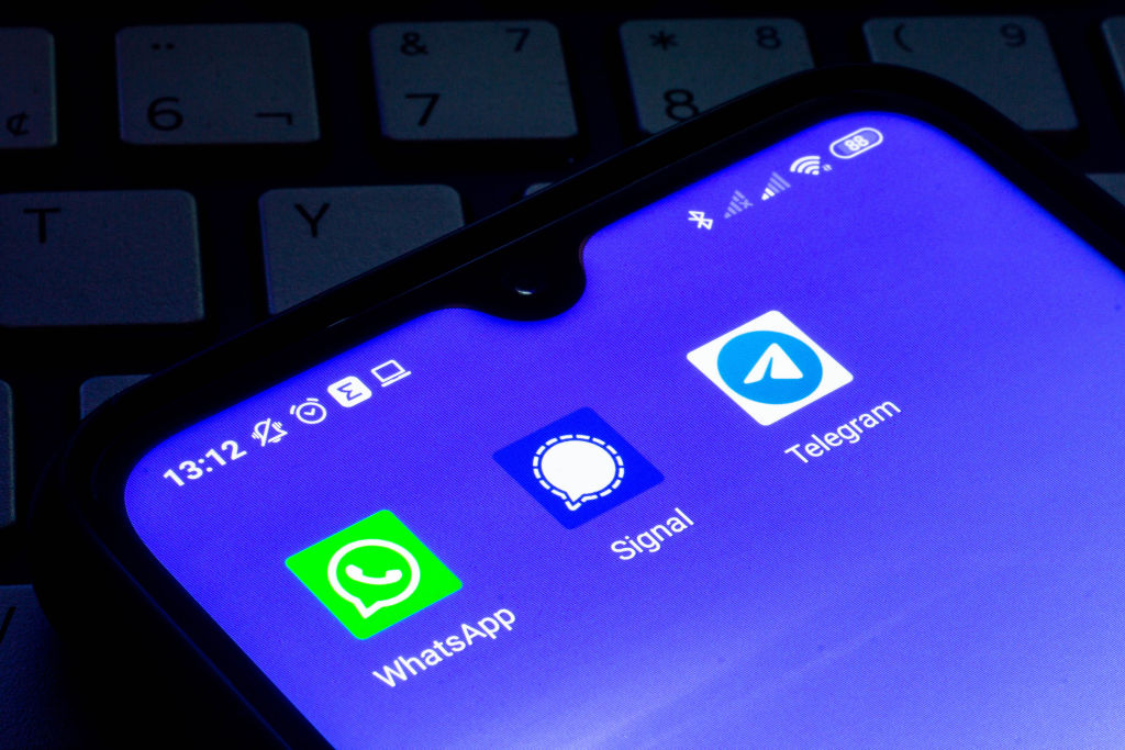 Een foto van de diensten Telegram, WhatsApp en Signal op een smartphone