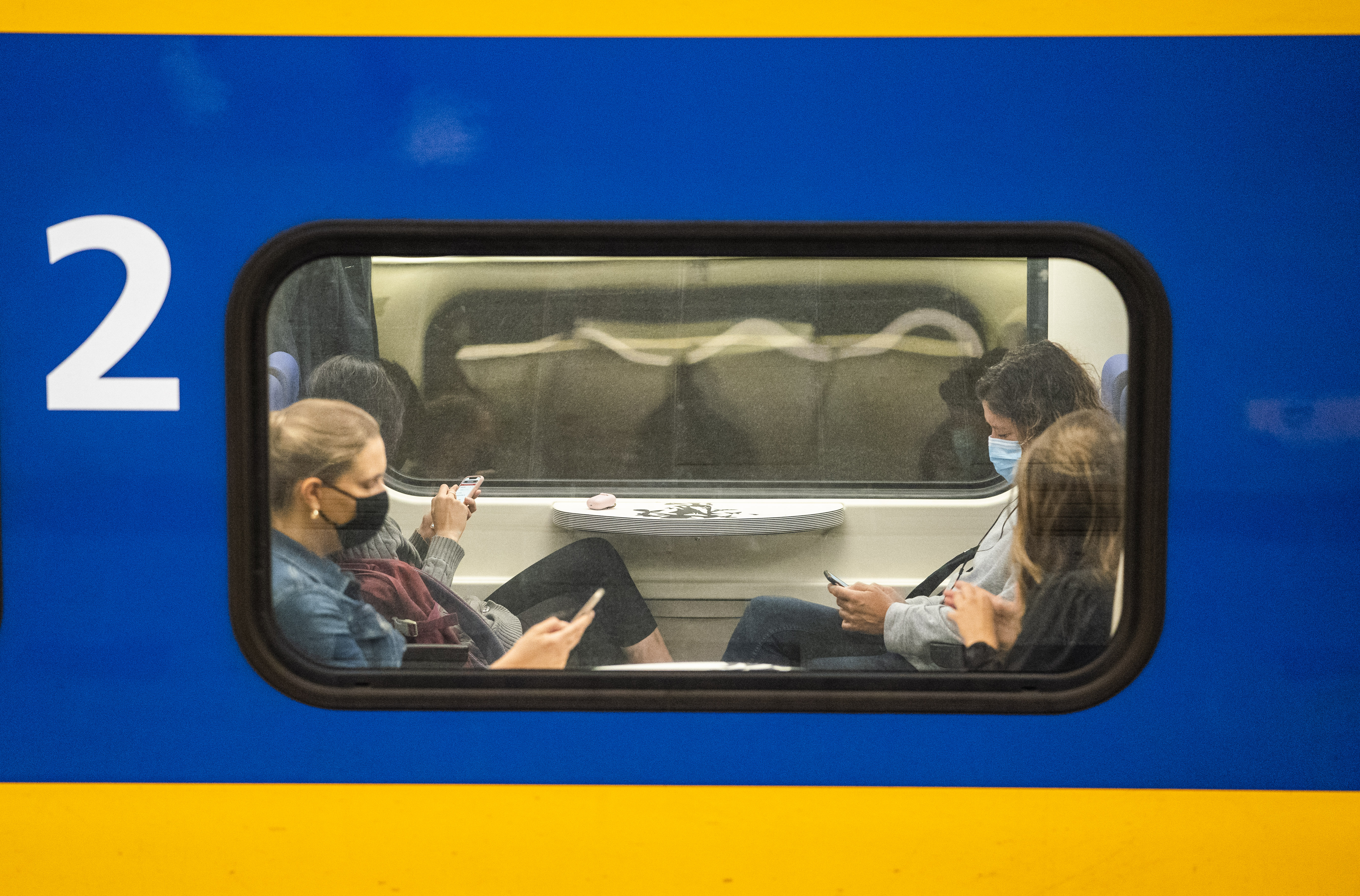 Openbaar vervoer NS trein druk mensen op telefoon