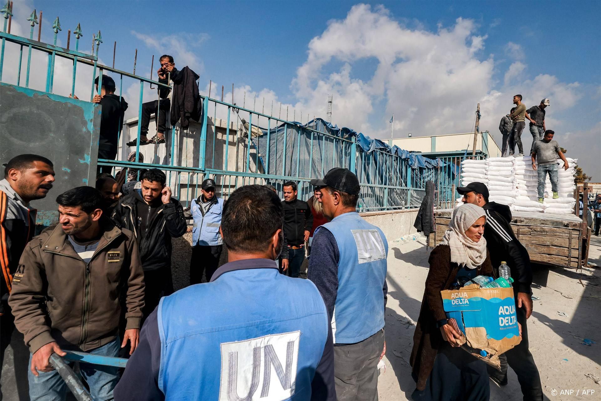 Workers of the United Nations Relief and Works Agency for Palestine Refugees (UNRWA) hand out flour rations and other supplies to people at an UNRWA warehouse in Rafah in the southern Gaza Strip on December 12, 2023, amid continuing battles between Israel and the militant group Hamas. 
MOHAMMED ABED / AFP