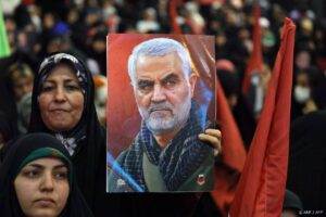 An Iranian woman holds a portrait of slain top Iranian commander Qasem Soleimani during the commemoration ceremony marking the anniversary of his killing in the Iranian capital Tehran on January 3, 2024.  Twin bomb blasts killed at least 103 people in Iran, ripping through a crowd commemorating Revolutionary Guards general Qasem Soleimani four years after his death in a US strike, state media reported. 
ATTA KENARE / AFP
