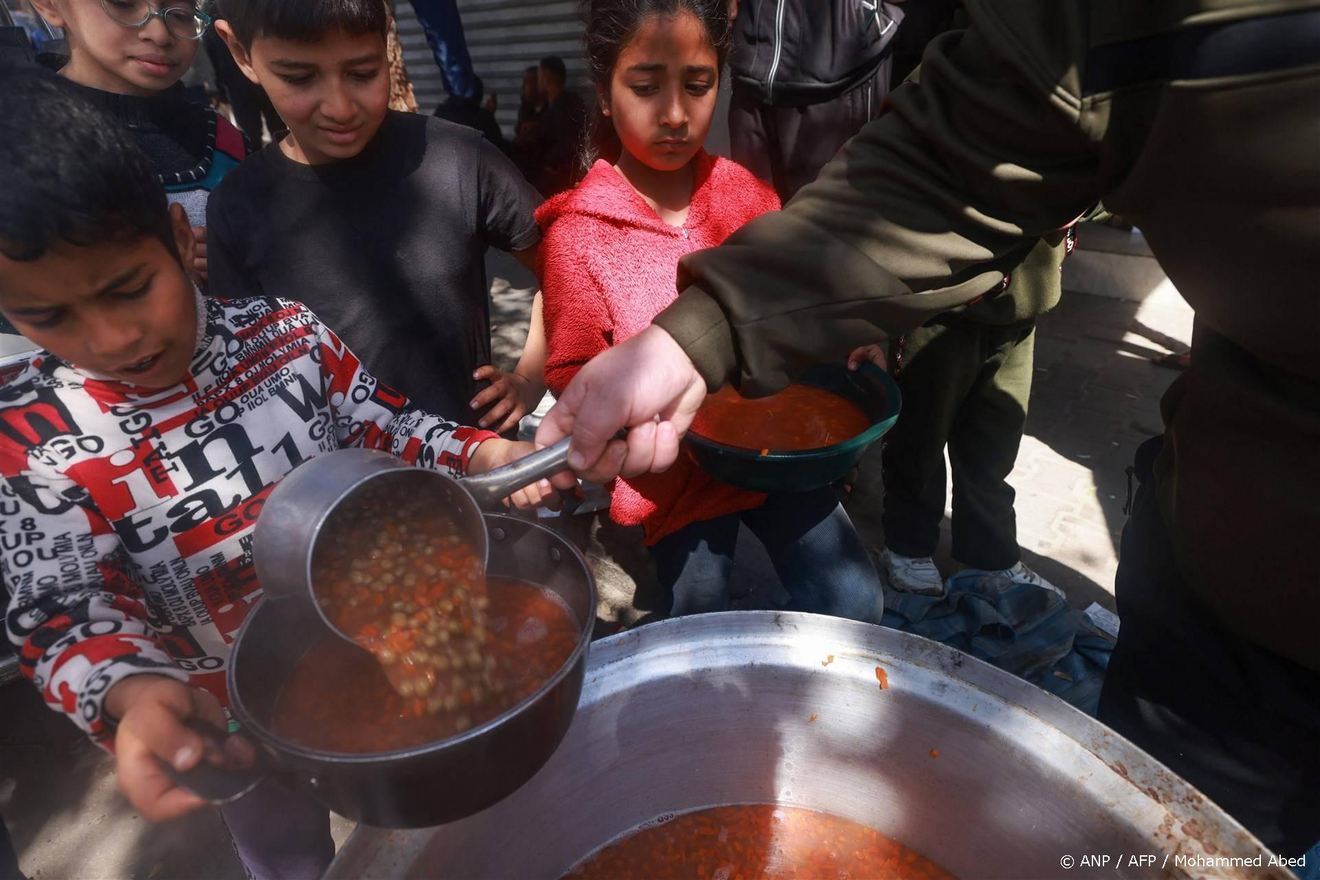 Palestinian children receive cooked food rations as part of a volunteer youth initiative in Rafah in the southern Gaza Strip, on March 5, 2024, amid widespread hunger in the besieged Palestinian territory as the conflict between Israel and the Palestinian militant group Hamas continues. 
MOHAMMED ABED / AFP