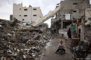 A Palestinian child rides a bicycle near a fallen minaret of a destroyed mosque during the Muslim holy fasting month of Ramadan, in the Nuseirat refugee camp in the central Gaza Strip on March 7, 2025.   
Eyad BABA / AFP