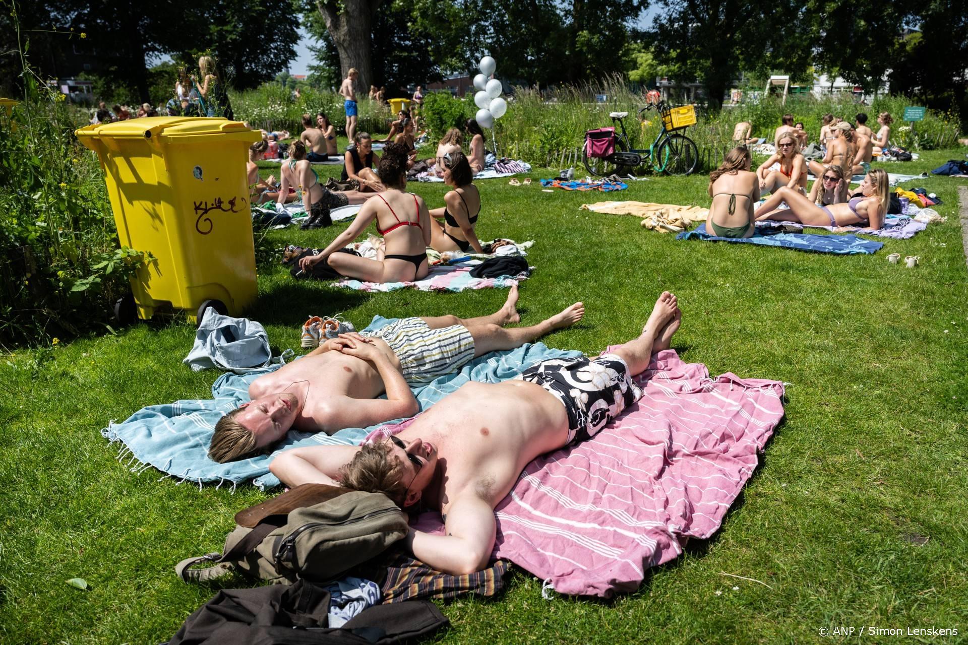 AMSTERDAM - Zonaanbidders op het Marineterrein in de hoofdstad, op een zomers warme lentedag. De populaire zwemplek is sinds dit jaar een officiele zwemlocatie waar de waterkwaliteit wordt gemeten. ANP SIMON LENSKENS