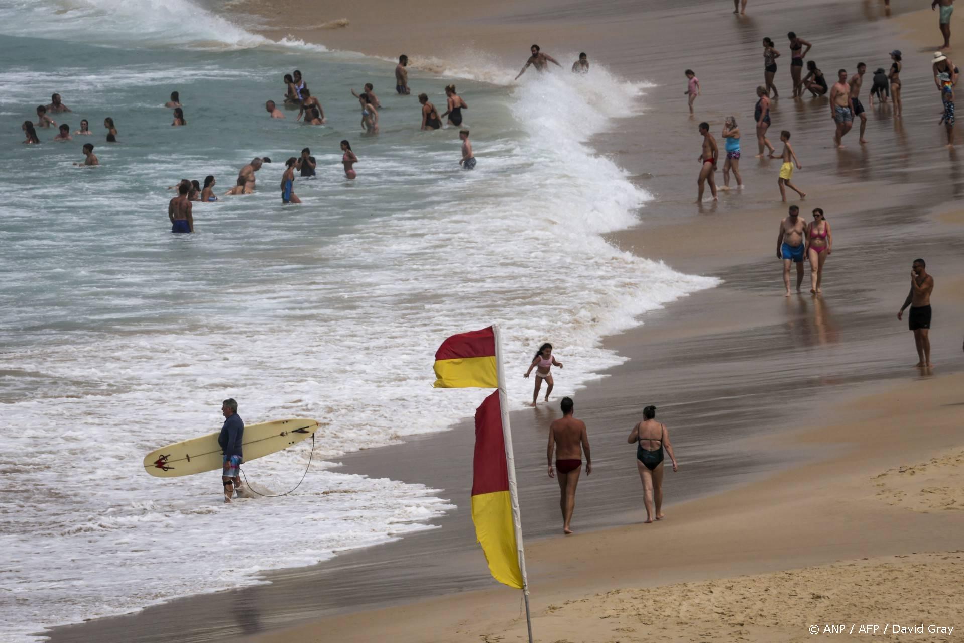 People swim and walk along Bondi Beach on a hot and windy spring day in Sydney on October 22, 2025.
DAVID GRAY / AFP