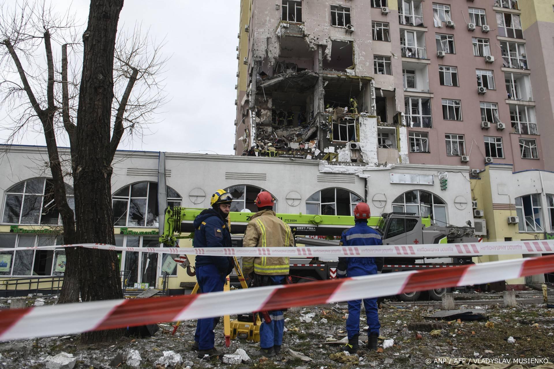 Ukrainian rescuers stand in front of a damaged residential building following Russian drones and missiles attack in Kyiv, on December 27, 2025, amid the Russian invasion in Ukraine. Russia pummelled Ukraine's capital with drones and missiles on December 27, killing a woman and cutting power to hundreds of thousands, ahead of the latest talks between the presidents of Ukraine and the US.

VLADYSLAV MUSIENKO / AFP
