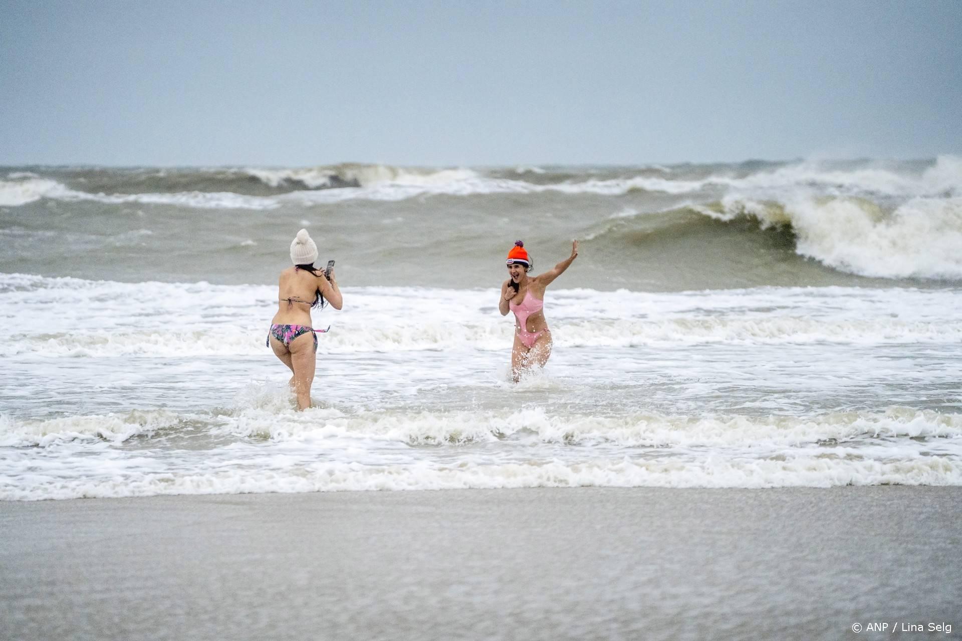 SCHEVENINGEN - Mensen rennen op het strand van Scheveningen de zee in op het moment dat de traditionele nieuwjaarsduik zou plaatsvinden. Vanwege de harde wind is onder meer de bekendste nieuwjaarsduik afgelast. ANP LINA SELG